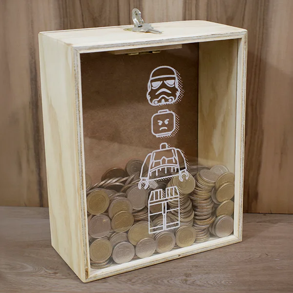 Alcancía en madera personalizada de 25 x 20 x 10 cm 1 Alcancía en madera triplex de pino con acrílico transparente vista tres cuartos en uso