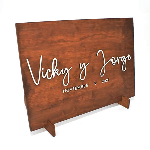 Letrero para boda de madera 4 Letrero para boda en madera color miel con nombres personalizados en letras blancas.