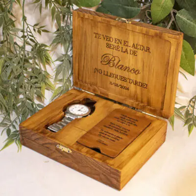 El Caja de Madera Personalizado para Reloj es un producto excepcionalmente diseñado que combina funcionalidad y estética. Este cofre, fabricado con madera de pino de 18 mm de espesor, ofrece un espacio seguro y elegante para guardar y presentar un reloj y anillos de compromiso, convirtiéndose en un elemento esencial en cualquier celebración romántica. Las dimensiones del cofre son 18 x 13,5 x 5,3 cm de alto, proporcionando un espacio adecuado para el reloj y los anillos. Este tamaño cuidadosamente calculado asegura que el reloj y los anillos se ajusten perfectamente, protegidos y presentados de manera elegante. El cofre es lo suficientemente compacto para ser transportado con facilidad, pero lo suficientemente espacioso para albergar el reloj y los anillos sin problemas. El acabado pintado resalta la belleza natural de la madera de pino, aportando un toque de sofisticación y elegancia. La madera de pino, conocida por su durabilidad y atractivo estético, se ha utilizado para garantizar que el cofre no solo sea funcional, sino también atractivo. La elección de la madera de pino también refleja un compromiso con la sostenibilidad, ya que este material es renovable y de origen responsable. La personalización en grabado láser en la tapa externa, interna y la tapa del compartimiento añade un toque personalizado. Esta atención al detalle permite que cada cofre sea único, reflejando el carácter individual de cada celebración de compromiso. La posibilidad de personalizar el cofre significa que puede adaptarse a las preferencias personales, haciendo de cada cofre un artículo verdaderamente único. Este cofre es más que un simple contenedor; es un símbolo de compromiso y amor. En bodas y celebraciones románticas, un detalle como este puede tener un significado profundo. Representa la promesa de un futuro compartido y la importancia de los momentos que se atesoran. Al elegir este cofre para presentar un reloj de compromiso, se está haciendo una declaración de intenciones, reconociendo la importancia del paso que se está dando. Además, el Caja de Madera Personalizado para Reloj es respetuoso con el medio ambiente. La madera utilizada proviene de fuentes sostenibles y renovables, lo que significa que su fabricación no compromete la naturaleza. Este compromiso con la sostenibilidad se refleja en cada aspecto del diseño del cofre, desde la elección de los materiales hasta el proceso de fabricación.