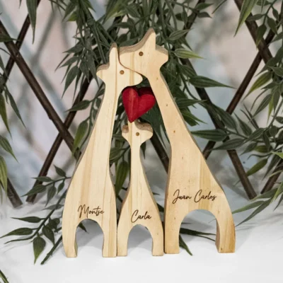 Vista frontal de escultura de 3 jirafas en madera de pino con nombres grabados en láser.