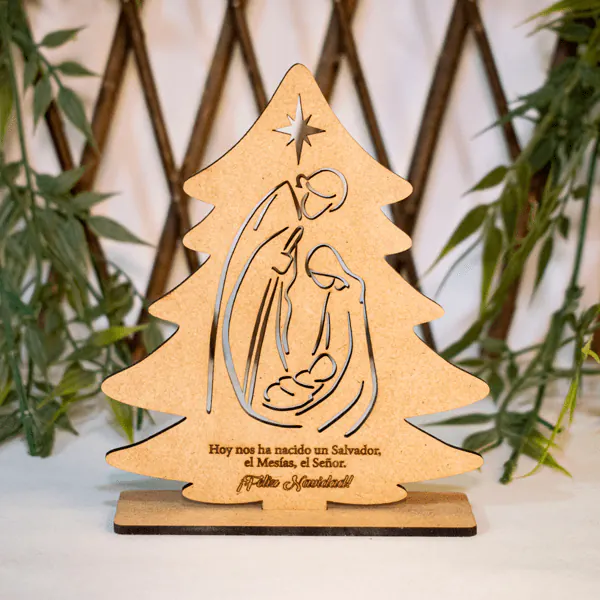 Adorno Árbol de Navidad Pesebre en MDF Decorativo | Trazos de Arte Adorno decorativo Árbol de Navidad Pesebre en MDF de 12 cm de alto, 10 cm de largo y 3 cm de ancho. Representa la Sagrada Familia con el niño Jesús, María, José y la estrella de Belén, grabado en diseño minimalista con láser. Ideal para mesas y repisas, su base es estable y ligera. Fabricado bajo pedido con posibilidad de personalización, perfecto como decoración navideña o regalo único. El acabado natural rústico aporta calidez y elegancia, siendo un símbolo significativo del espíritu navideño que destaca en cualquier espacio.
