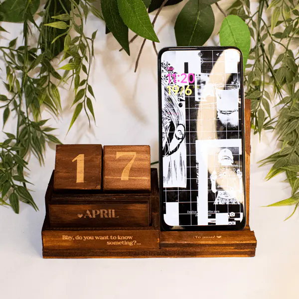 Calendario de Madera y Soporte Celular Calendario de Madera y Soporte para Celular, fabricado en madera natural con dimensiones de 12 cm de alto, 19 cm de largo y 8 cm de ancho. Incluye un calendario perpetuo con bloques grabados y un soporte integrado para celular. Personalizable con grabado láser, ideal para uso decorativo y funcional.