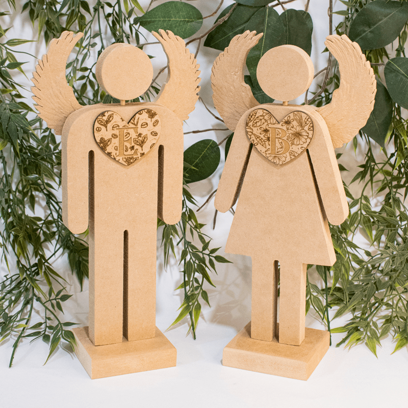 Encantadora pareja de ángeles de madera, ideales para decorar cualquier espacio con un toque de romanticismo y espiritualidad. Cada figura representa un género, con alas delicadas y un corazón personalizado en el centro del pecho. Los corazones están decorados con intrincados diseños florales y las iniciales de cada persona, lo que los convierte en un regalo perfecto para parejas. Su diseño sencillo y atemporal los hace versátiles para adaptarse a cualquier estilo de decoración.