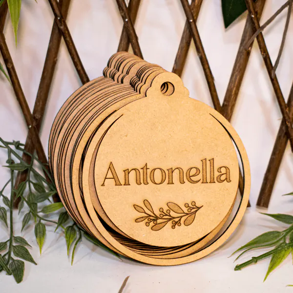 Esfera Navideña Personalizada en MDF | Trazos de Arte Esfera Navideña Personalizada en MDF, diseñada con precisión en dimensiones de 11 cm de alto, 10 cm de largo y 0,25 cm de ancho. Fabricada bajo pedido, incluye personalización mediante grabado láser que asegura un diseño detallado y único. Ideal como adorno decorativo para árboles, espacios festivos o como regalo simbólico y significativo durante la Navidad.