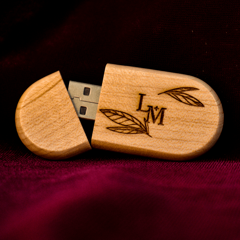 Elegante dispositivo de almacenamiento USB con una carcasa de madera de arce natural. Su diseño ovalado y compacto lo hace fácil de transportar, mientras que el grabado láser personalizado con las iniciales 