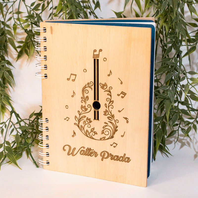 Elegante cuaderno de 80 hojas cuadriculadas, elaborado en triplex de pino. Su tapa está personalizada con un diseño de guitarra y notas musicales, grabado a láser, lo que le otorga un toque artístico y musical. Las hojas cuadriculadas son ideales para tomar notas, dibujar o escribir, mientras que la encuadernación en espiral permite una apertura completa y facilita la escritura. Este cuaderno es un regalo perfecto para músicos, amantes de la música o cualquier persona que aprecie los objetos hechos a mano y personalizados.