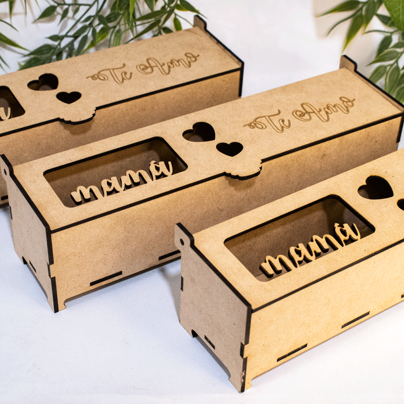 Tres elegantes cajas rectangulares de madera, dispuestas en fila. Cada caja presenta un diseño sencillo y sofisticado, con líneas rectas y un tono de madera natural. En la parte frontal de cada caja, se aprecia un corte láser que forma la frase 