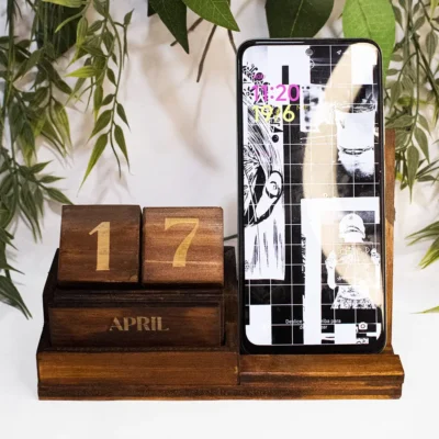 Calendario perpetuo de madera de pino con soporte para celular y grabado láser mostrando ejemplo de uso.